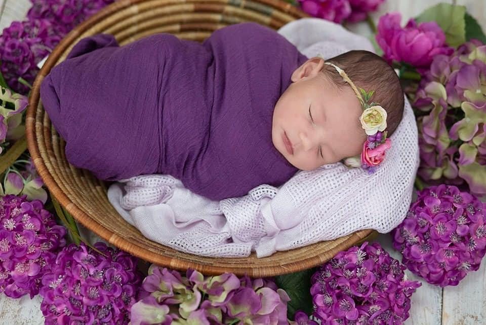 Newborn baby wrapped in a knit blanket, studio session